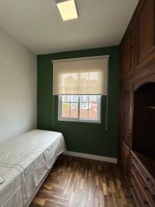 a bedroom with a bed and a window at Sobrado da Matriz in São Lourenço