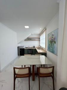 a kitchen with a table and chairs and a sink at Sobrado da Matriz in São Lourenço