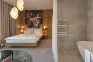 a bedroom with a king sized bed and a bathroom at Hotel Bronzo Brno in Brno