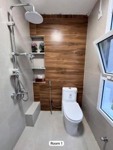 a bathroom with a toilet and a wooden wall at Hawer Inn - wadi bani Khalid in Biḑ‘ah