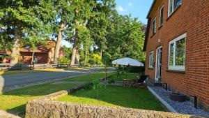a yard with a table and an umbrella next to a building at Ferienwohnungen Walsrode NR1EG in Stellichte