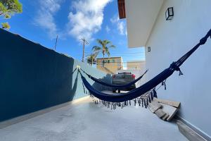 a hammock hanging from a wall next to a building at Bertioga Sobrado Piscina 90m da Praia da Enseada in Bertioga