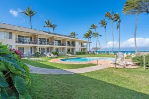 a resort with a swimming pool and palm trees at Napili Surf 207 · NSF 207 BeachFront Condo Napili Bay in Kahana