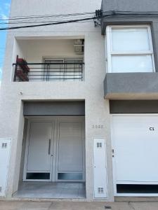 エスペランサにあるDepartamento en Esperanzaのガレージドア2つとバルコニー付きの建物