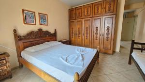 Un dormitorio con una cama con cabecero de madera. en Atlântico Sul Renascença Hotel, en Laguna