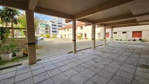 un patio vacío con columnas y un estacionamiento en Atlântico Sul Renascença Hotel, en Laguna 3 fotos más