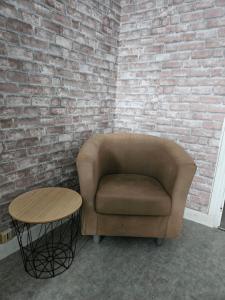 a chair and a table in front of a brick wall at Alphonse in Felletin