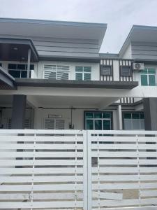 a white fence in front of a house at Anis Homestay MELAKA in Melaka