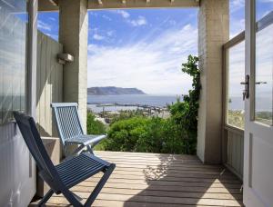 two chairs on a porch with a view of the ocean at LIMA HOUSE, Seaforth, Simon's Town in Simonʼs Town