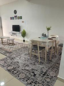 a dining room with a table and chairs on a rug at Anis Homestay MELAKA in Melaka