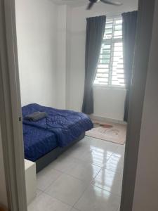 a bedroom with a blue bed and a window at Anis Homestay MELAKA in Melaka