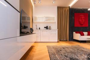 eine Küche mit weißen Schränken und einem roten Gemälde in der Unterkunft Arbio I Urban Apartment Zimmerstrasse in Leipzig