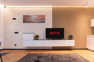 ein Wohnzimmer mit einem TV auf einem weißen Entertainment-Center in der Unterkunft Arbio I Urban Apartment Zimmerstrasse in Leipzig