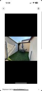 vistas a un patio con mesa y sombrilla en Petit studio à la campagne, en Angerville-la-Martel