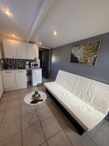 una sala de estar con un sofá y una mesa en Petit studio à la campagne, en Angerville-la-Martel