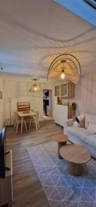 a living room with a couch and a table at Maisonnette 1 chambre, Terrasse, Calme et Parking in Auxerre