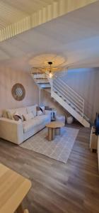 a living room with a white couch and a staircase at Maisonnette 1 chambre, Terrasse, Calme et Parking in Auxerre