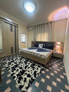 een slaapkamer met een bed en een zwart-wit tapijt bij Residence FATIMA thies in Thiès