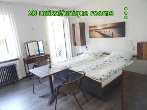 a bedroom with a bed and a table and chairs at Eventhotel Ö - Cappuccino in Geiselwind