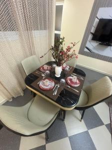 een eettafel met stoelen en een zwarte tafel bij Residence FATIMA thies in Thiès