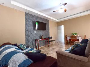 a living room with a couch and a tv on a wall at Casa c Piscina e Churrasqueira na Represa de Avare in Avaré