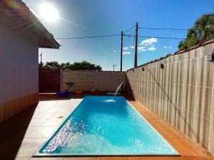 a swimming pool in a backyard next to a fence at Casa c Piscina e Churrasqueira na Represa de Avare in Avaré