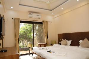 a hotel room with a bed and a window at Maitri Retreat in Panchgani