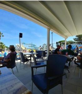 a group of people sitting at tables on a patio at Bungalow 410, 8 pers Camping 4 étoiles Siblu Le Lac des Rêves in Lattes +32 photos