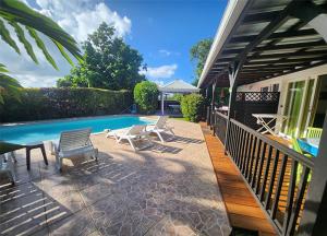 a patio with chairs and a swimming pool at Kasa Vanille in Sainte-Luce