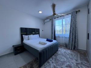 a bedroom with a bed with a large window at Hidden gem-Nyali Vale Residence in Mombasa +4 photos