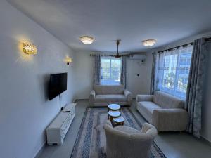 a living room with two couches and a tv at Hidden gem-Nyali Vale Residence in Mombasa