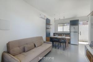 a living room with a couch and a kitchen at Aptos em condo. com churrasq. e piscina na melhor localização de Porto Seguro – DVBs in Porto Seguro +9 photos
