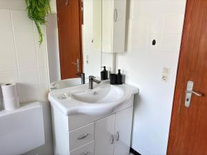 a white bathroom with a sink and a toilet at Three room apartment in Bad Oeynhausen Südbahnhof in Bad Oeynhausen +13 photos