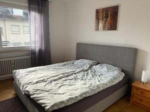 an unmade bed in a bedroom with a window at Three room apartment in Bad Oeynhausen Südbahnhof in Bad Oeynhausen