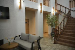 a living room with a couch and a staircase at Hills Hotel in Karakol