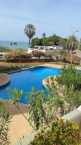 ein blauer Pool mit dem Ozean im Hintergrund in der Unterkunft Apartamento con Vista al mar y Terraza, Isla de Margarita in Pampatar