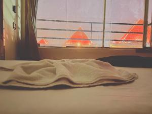 a blanket laying on a bed in front of a window at Continental Pyramids Terrace Hotel in Cairo