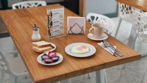 une table avec un petit-déjeuner composé d'œufs et de pain dans l'établissement Poblado Park Guest House, à Medellín