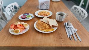 une table avec des assiettes de petit-déjeuner et une tasse de café dans l'établissement Poblado Park Guest House, à Medellín