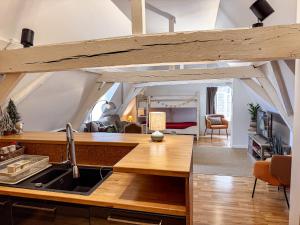 a kitchen with a sink and a living room at Skindles Guesthouse in Poperinge