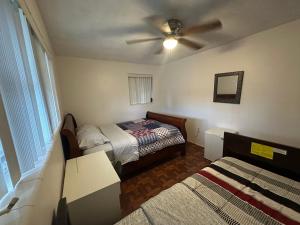 a bedroom with two beds and a ceiling fan at Hermosas habitaciones in Pembroke Pines