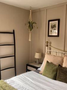 a bedroom with a bed and a plant on the wall at Two Bedroom House in the Heart of Winchester in Winchester