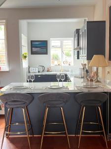a kitchen with a counter with two bar stools at Two Bedroom House in the Heart of Winchester in Winchester