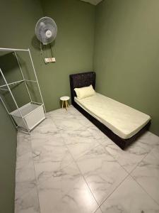 a bedroom with a bed and a fan at Rina Hostel in Ipoh