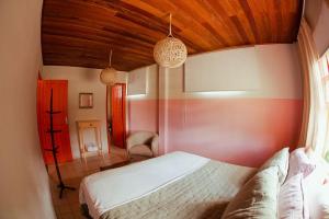 ein Schlafzimmer mit einem weißen Bett und einer Holzdecke in der Unterkunft Casarão in Marechal Floriano