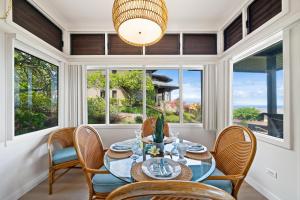 a dining room with a table and chairs and windows at Kapalua Ridge Villas 1011 · KRV 1011 Oceanview Condo + Golf + Lu in Kahana