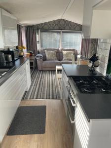 GuntonにあるTingdene caravan parkのキッチン、リビングルーム(ソファ付) +16枚の写真