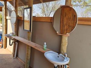 a bathroom with a sink and a mirror at Khwai Game Lodge and Campsite in Khwai