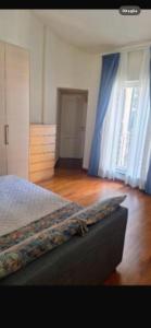 a bedroom with a bed with blue curtains and a wooden floor at Brera home suite in Milan