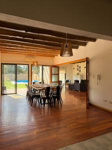 a dining room and living room with a table and chairs at Gran Casa con Piscina in Ciudad Lujan de Cuyo